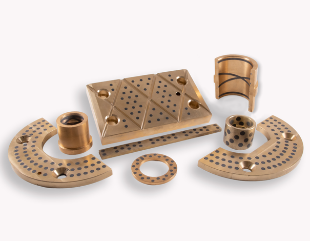 Graphite lubricated bronze bushings and bearings with grooves and plugs for self-lubrication.